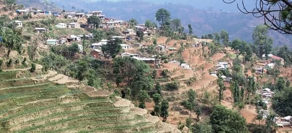 Terraced hillside in Sindhupalchowk scattered with tin-roofed houses among the fields